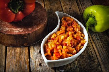 ahşap bir masada pirinç ve domates sosu ile biber