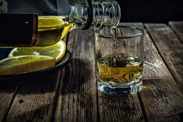 Whisky Giet Van Een Fles Een Stapel Een Houten Ondergrond — Stockfoto
