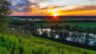 Akşam nehri ve ufukta güneş ışığı olan güzel bir manzara..