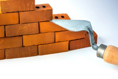 Beyaz zemin üzerinde tuğla bloklar ve mala mason