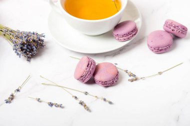 Lavantalı badem kurabiyeleri beyaz bir masada, düz yerde.