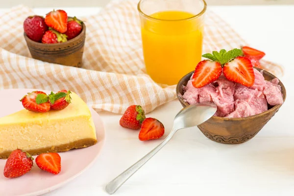 Helado de fresa y tarta de queso en una mesa blanca —  Fotos de Stock