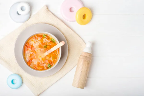 Healthy natural eco baby lure. Soup of squash, carrot, onion, cabbage, potato in plate and with spoon on wooden background with copy space — Stock Image Healthy Natural Eco Baby Lure Soup Squash Carrot Onion Cabbage Stock Picture