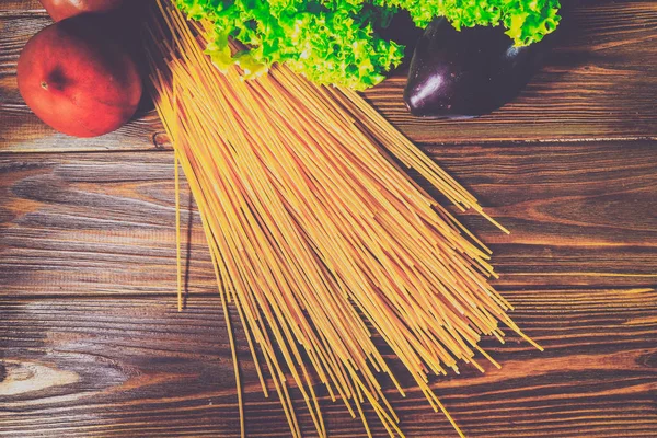 Spagetti ve sebze ahşap arka plan üzerinde