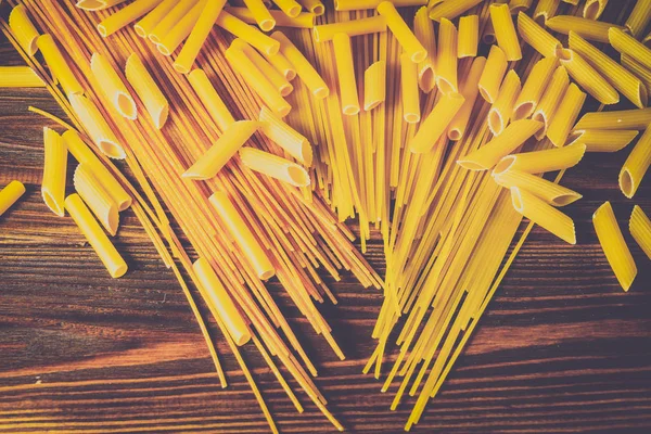 Ahşap arka planda farklı türde makarna.