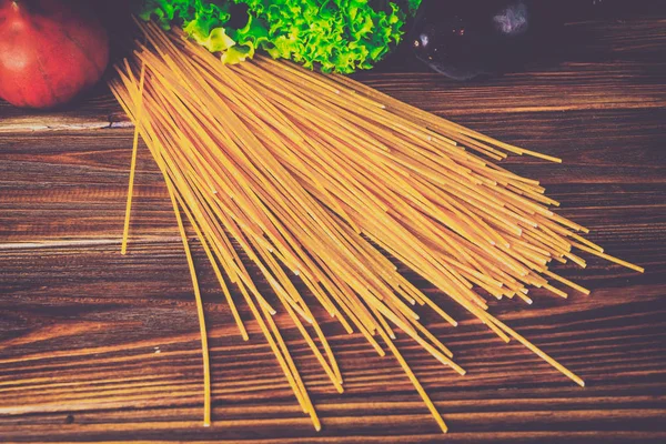 Spagetti ve sebze ahşap arka plan üzerinde