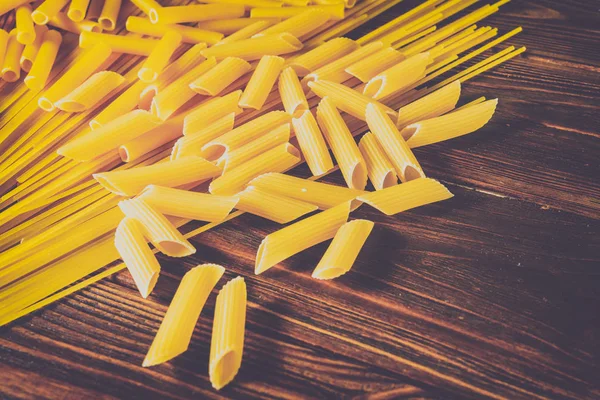 Ahşap arka planda farklı türde makarna.