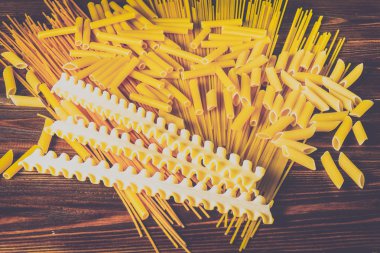 Ahşap arka planda farklı türde makarna.