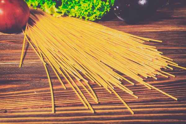 Spagetti ve sebze ahşap arka plan üzerinde