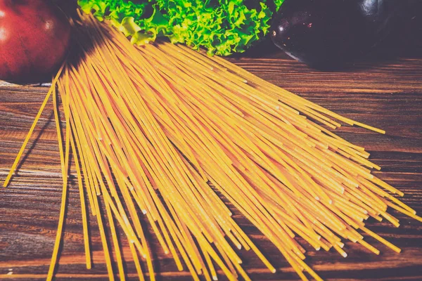 Spagetti ve sebze ahşap arka plan üzerinde