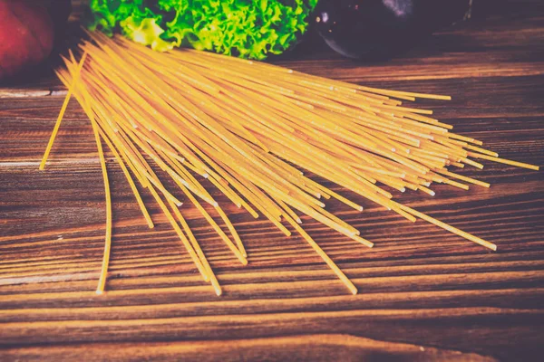 Spagetti ve sebze ahşap arka plan üzerinde