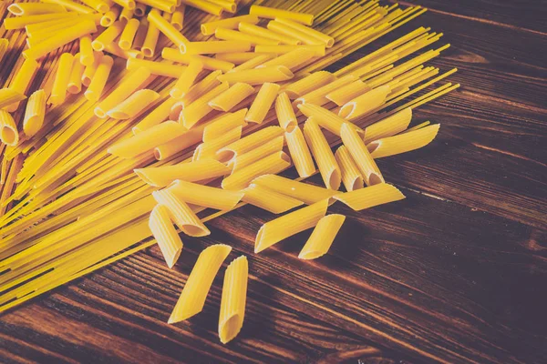 Ahşap arka planda farklı türde makarna.