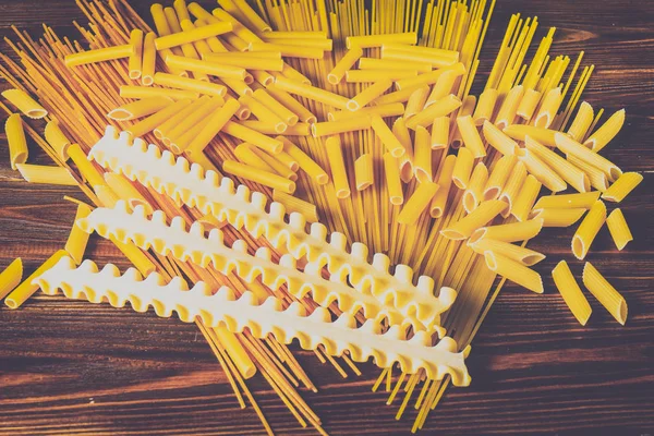 Ahşap arka planda farklı türde makarna.