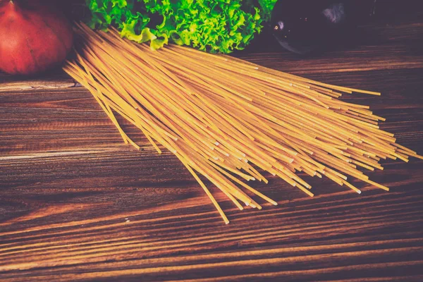 Spagetti ve sebze ahşap arka plan üzerinde