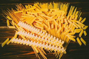 Ahşap arka planda farklı türde makarna.