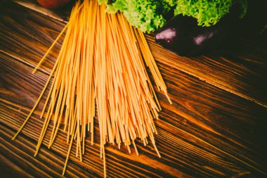 Spagetti ve sebze ahşap arka plan üzerinde