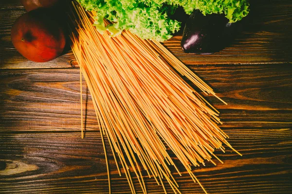 Spagetti ve sebze ahşap arka plan üzerinde