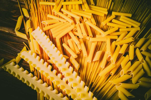 Ahşap arka planda farklı türde makarna.