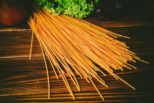 Spagetti ve sebze ahşap arka plan üzerinde