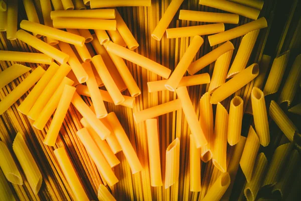 Ahşap arka planda farklı türde makarna.