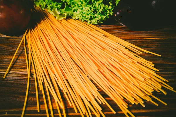 Spagetti ve sebze ahşap arka plan üzerinde