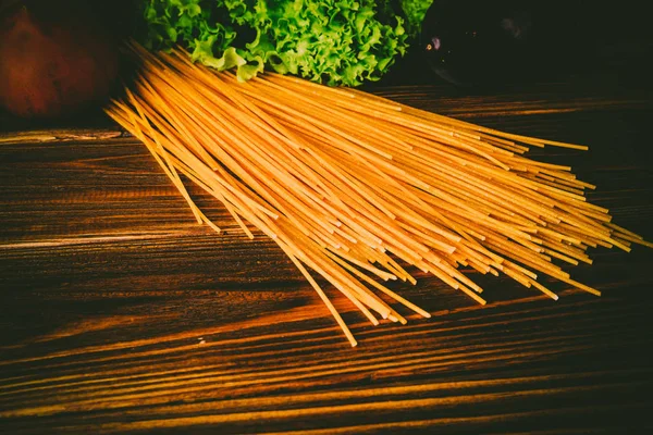 Spagetti ve sebze ahşap arka plan üzerinde