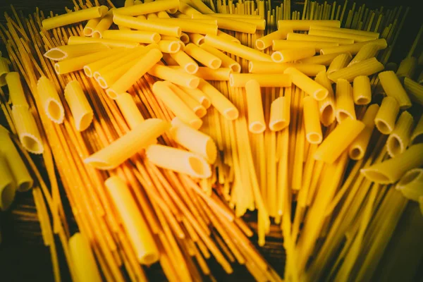 Ahşap arka planda farklı türde makarna.