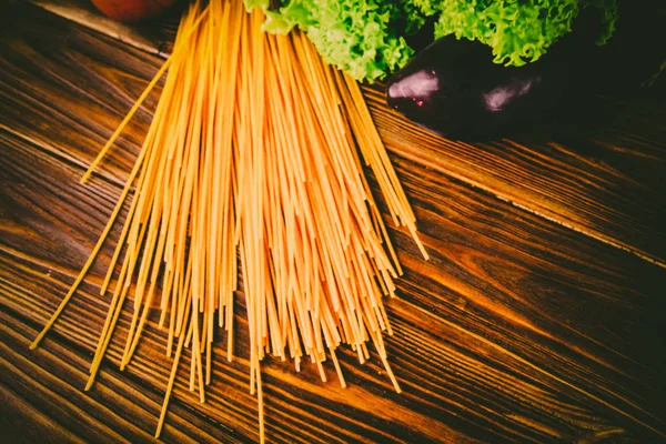 Spagetti ve sebze ahşap arka plan üzerinde