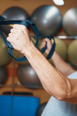 Genç adam bir spor salonunda trx devreye girer