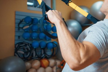 Genç adam bir spor salonunda trx devreye girer