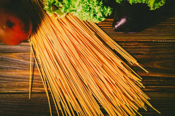Spagetti ve sebze ahşap arka plan üzerinde