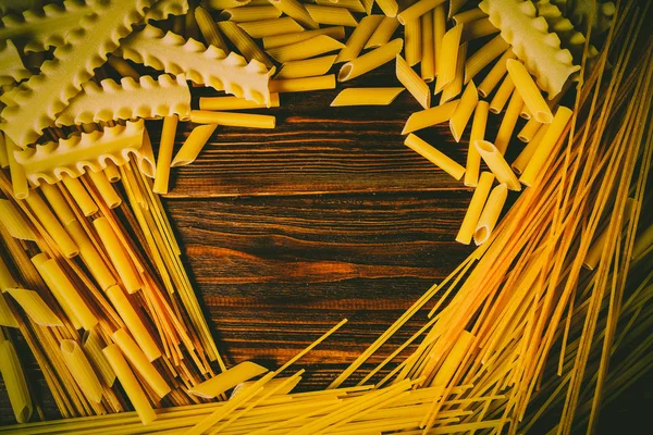 Ahşap arka planda farklı türde makarna.