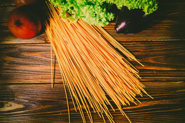 Spagetti ve sebze ahşap arka plan üzerinde