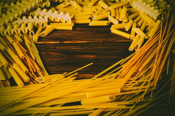 Ahşap arka planda farklı türde makarna.