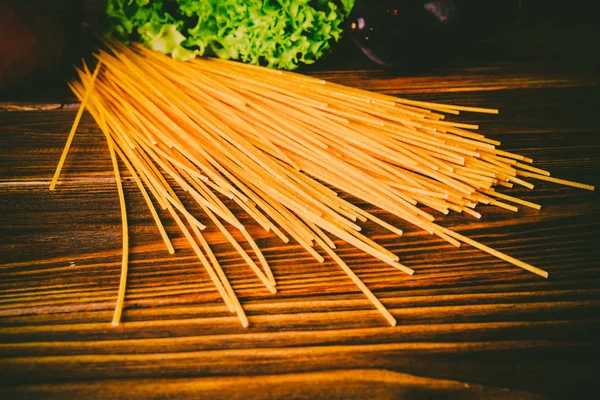 Spagetti ve sebze ahşap arka plan üzerinde