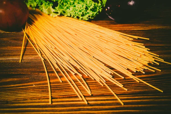 Spagetti ve sebze ahşap arka plan üzerinde