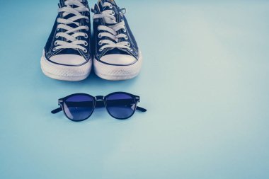 Spor ayakkabı, gözlük mavi bir arka plan üzerinde