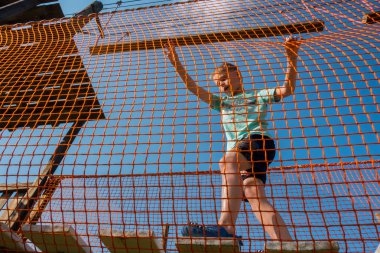 Çocuk ip parkında oynuyor.