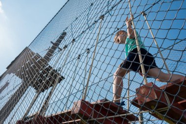 Çocuk ip parkında oynuyor.