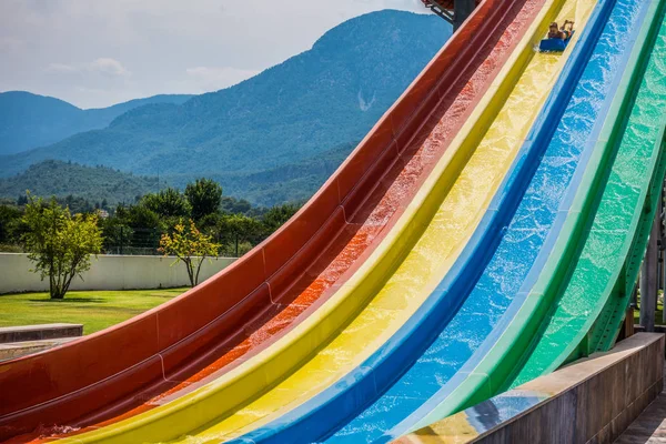 Montando escorregas de água no parque aquático — Fotografia de Stock