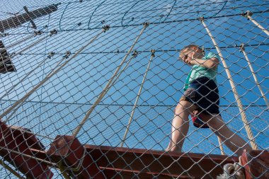 Çocuk ip parkında oynuyor.