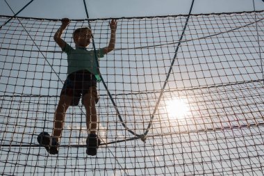 Çocuk ip parkında oynuyor.