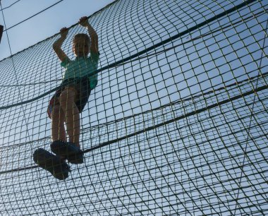 Çocuk ip parkında oynuyor.