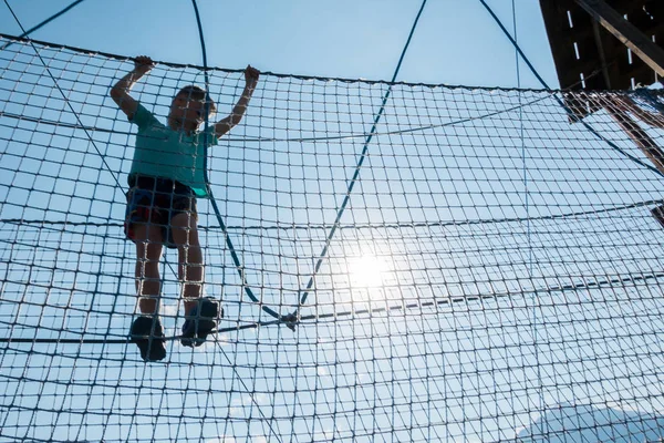 El chico juega en el parque de cuerdas — Foto de Stock