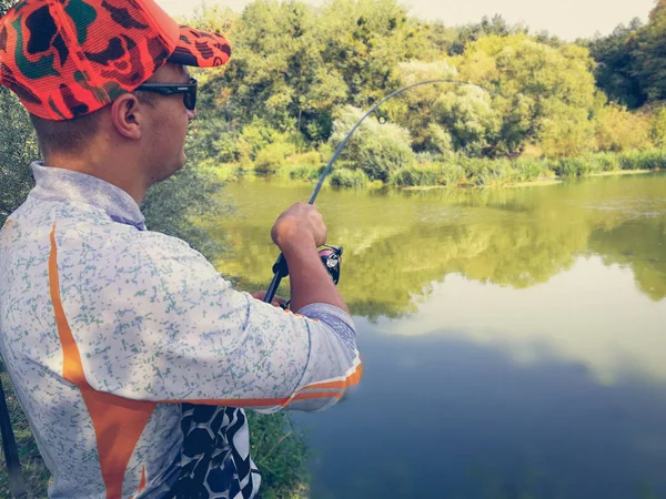 Рыбак рыбачит на озере летом — стоковое фото