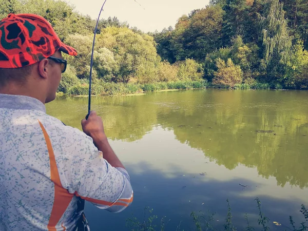 O pescador está pescando no lago no verão — Fotografia de Stock