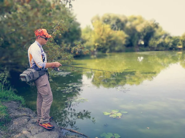 Молодий чоловік рибалить. боке, розмитий фон — стокове фото