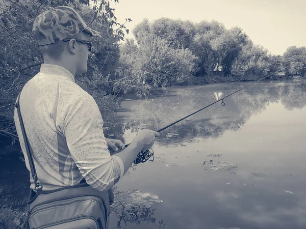 O pescador está pescando no lago no verão — Fotografia de Stock