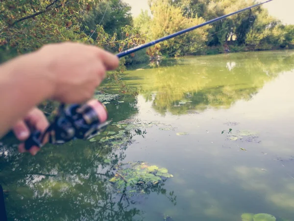 Mano di un pescatore con una canna da pesca — Foto Stock