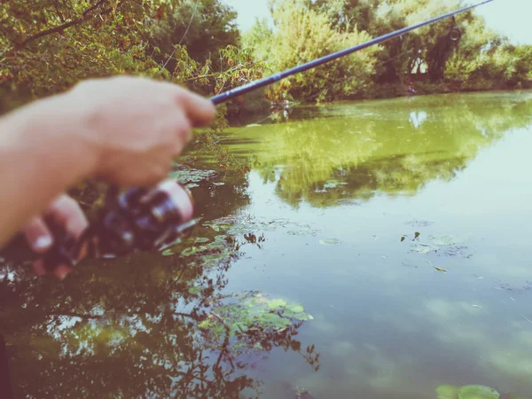 Mano di un pescatore con una canna da pesca — Foto Stock